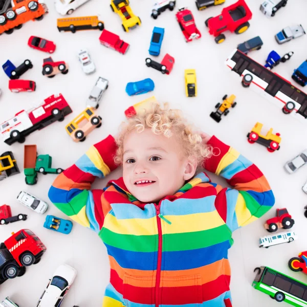Маленький хлопчик грає з іграшковими машинами — стокове фото