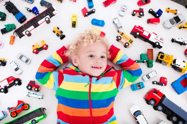 Küçük çocuk oyuncak arabalarla oynuyor. — Stok fotoğraf