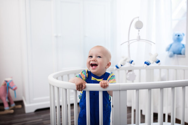 Малыш стоит в постели
