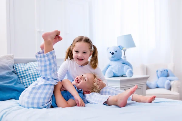Niños jugando en el dormitorio blanco —  Fotos de Stock
