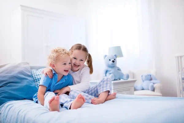 Niños jugando en el dormitorio blanco — Foto de Stock