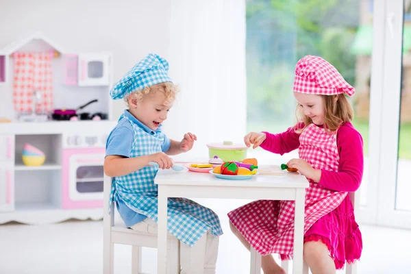 Kids playing with toy kitchen — Stock Photo, Image
