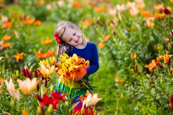 Menina colhendo flores de lírio — Fotografia de Stock