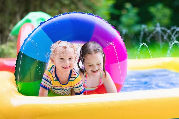 Kids playing in garden swimming pool — Stock Photo, Image
