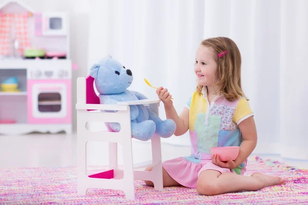 Menina alimentando seu urso de brinquedo — Fotografia de Stock