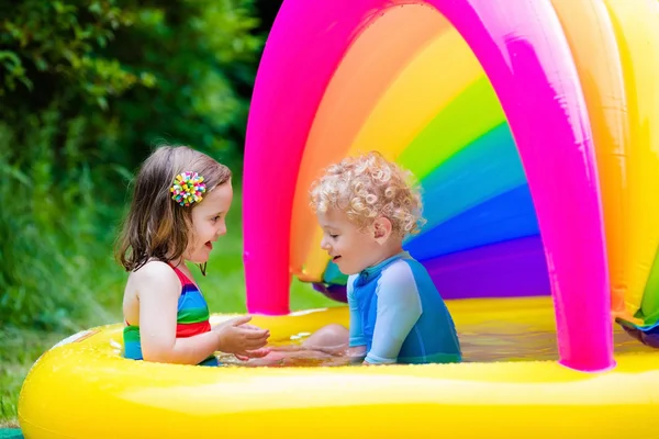 Barn som leker i uppblåsbar pool — Stockfoto