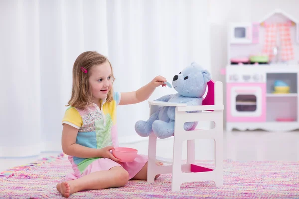 Niña alimentando a su oso de juguete — Foto de Stock