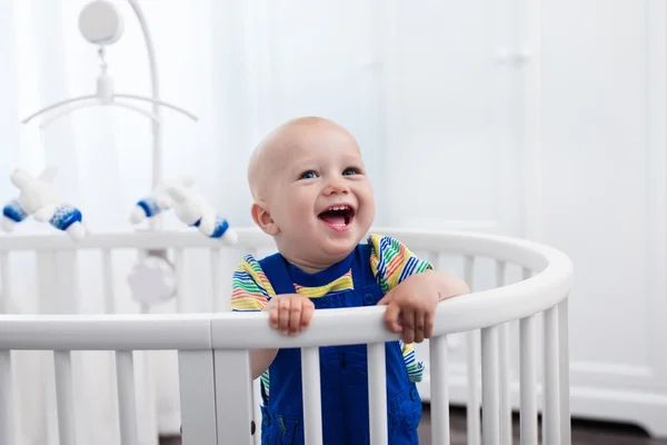 Baby boy standing in bed — Stock Photo, Image