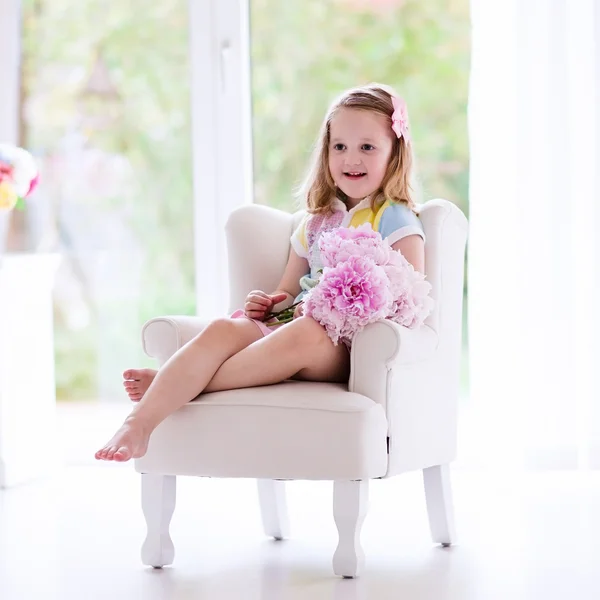 Little girl with peony flowers in white bedroom — Stock Photo, Image