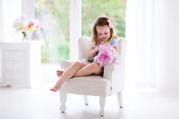 白い寝室で牡丹の花を持つ少女 — ストック写真