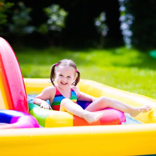 Маленькая девочка в саду бассейн — стоковое фото