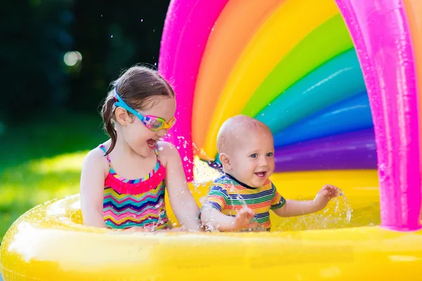 Kids playing in swimming pool — Stock Photo, Image