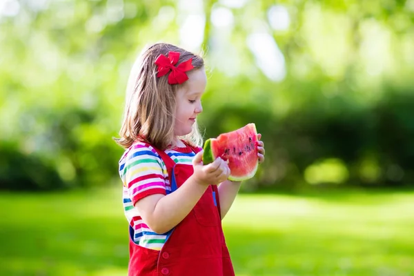 Niña comiendo sandía en el jardín — Foto de Stock