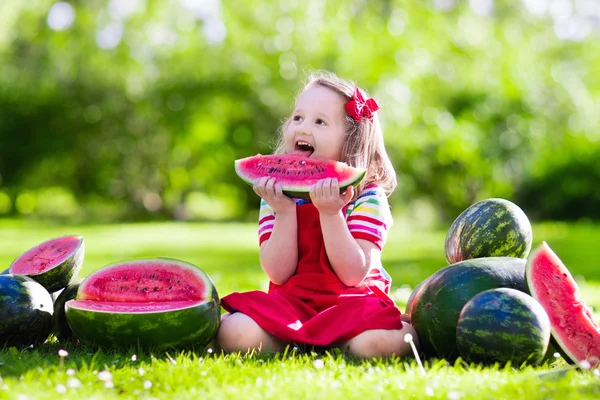 Menina comendo melancia no jardim — Fotografia de Stock