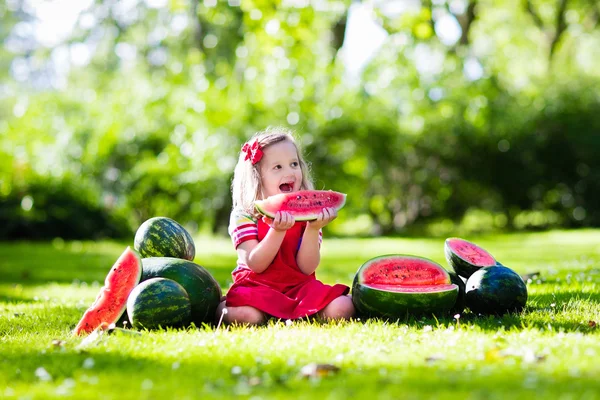 Mała dziewczynka jedzenie arbuza w ogrodzie — Zdjęcie stockowe