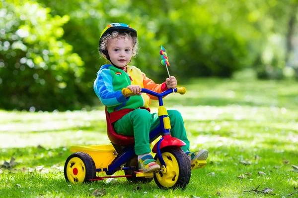 Malý chlapec na barevné tříkolky — Stock fotografie