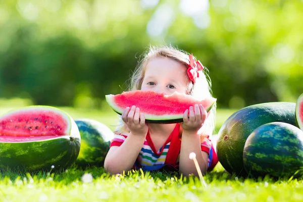 Kleines Mädchen isst Wassermelone im Garten — Stockfoto