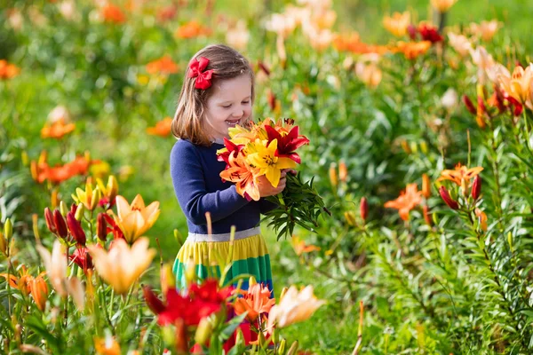 Menina colhendo flores de lírio — Fotografia de Stock