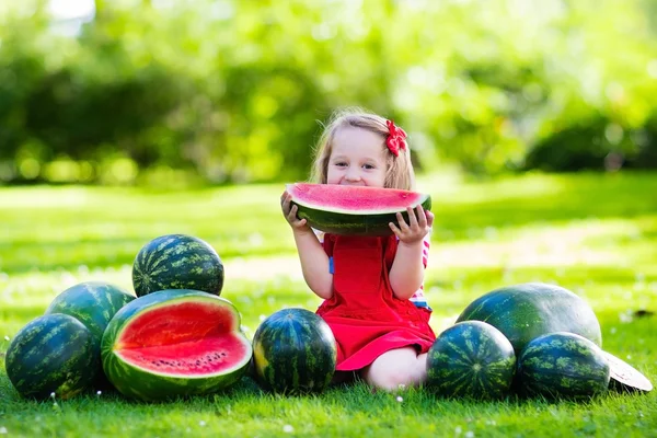 Petite fille mangeant pastèque dans le jardin — Photo