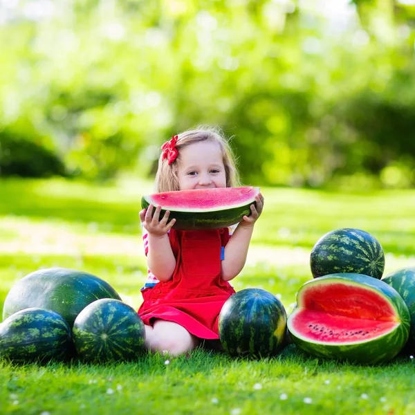 Petite fille mangeant pastèque dans le jardin — Photo