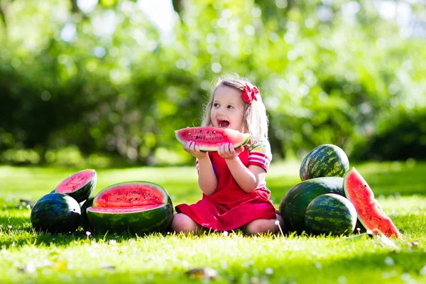 Kleines Mädchen isst Wassermelone im Garten — Stockfoto