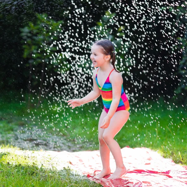 Дитина грає з садовим водяним гіркою — стокове фото