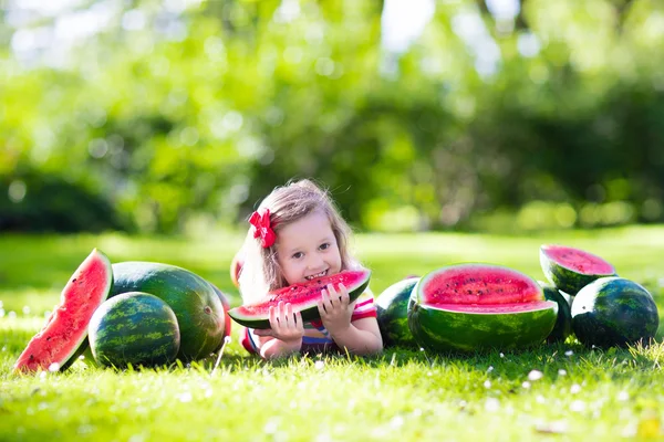 Kleines Mädchen isst Wassermelone im Garten — Stockfoto