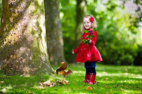 Little girl feeding squirrel — Stock Photo, Image