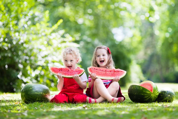 庭でスイカを食べる子供 — ストック写真