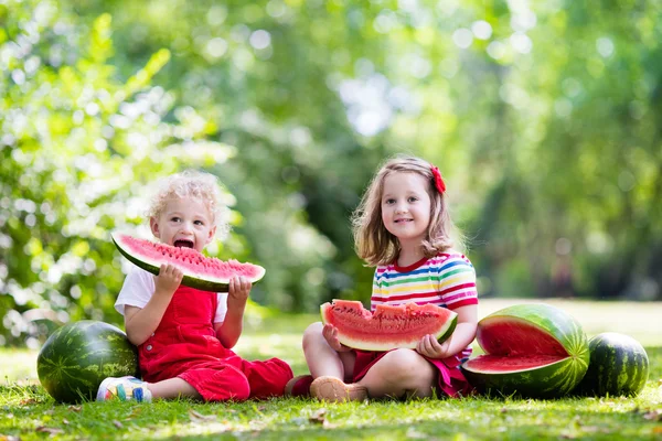 Дети едят арбуз в саду — стоковое фото