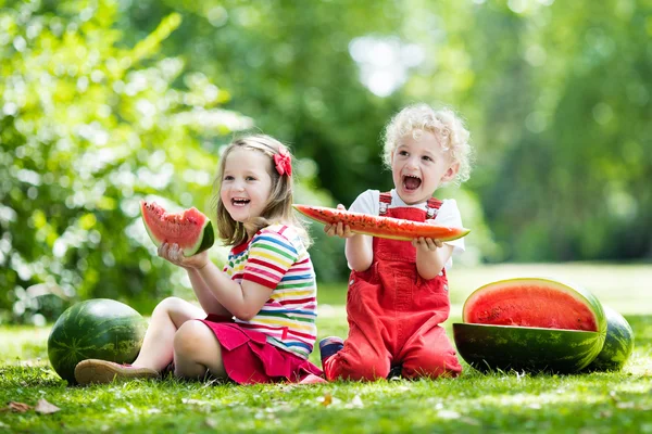 庭でスイカを食べる子供 — ストック写真