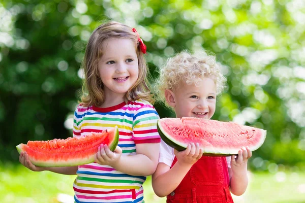 Kids eating watermelon in the garden — Stock Photo, Image