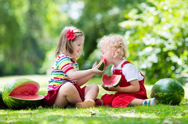 Kids eating watermelon in the garden — Stock Photo, Image