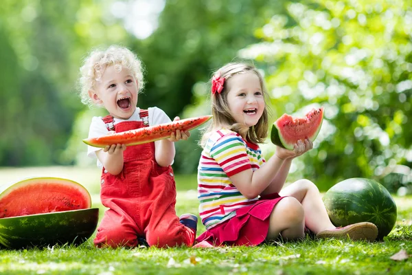 Kids eating watermelon in the garden — Stock Photo, Image
