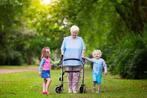 Nonna con walker che gioca con due bambini — Foto Stock