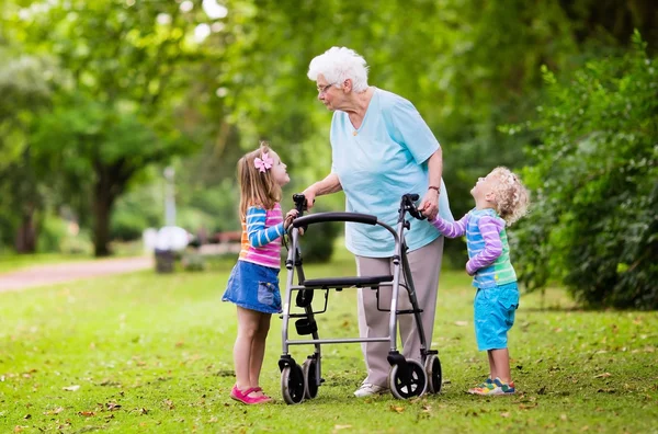 Grandmother with walker playing with two kids — Stock Photo, Image