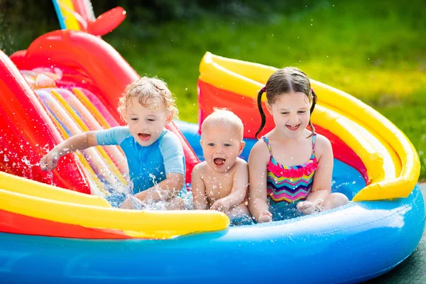 Crianças brincando na piscina inflável — Fotografia de Stock