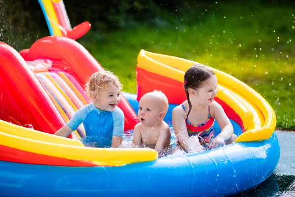 Niños jugando en piscina inflable — Foto de Stock