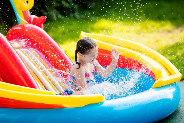 Little girl in garden swimming pool — Stock Photo, Image