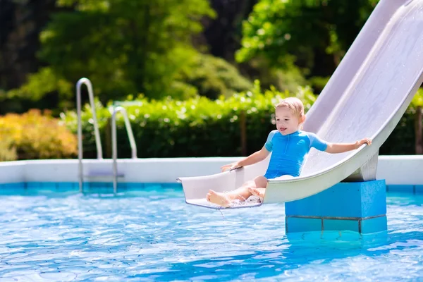 Lilla barnet på vattenrutschbana i poolen — Stockfoto