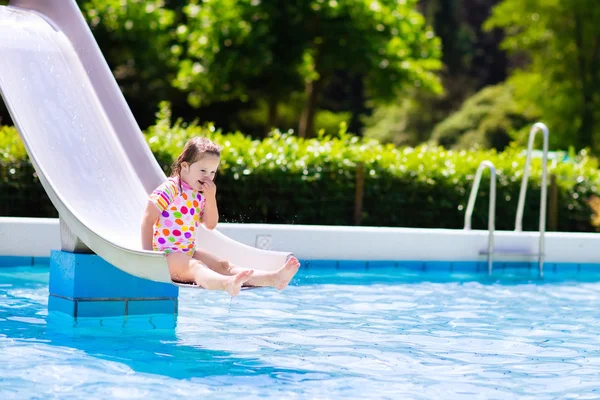 Little child on water slide in swimming pool — Stock Photo, Image