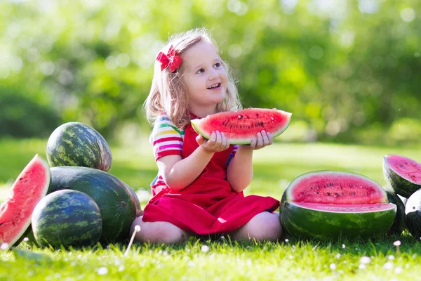 Kleines Mädchen isst Wassermelone im Garten — Stockfoto
