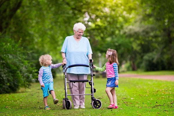 Babcia z walker, grając z dwójką dzieci — Zdjęcie stockowe