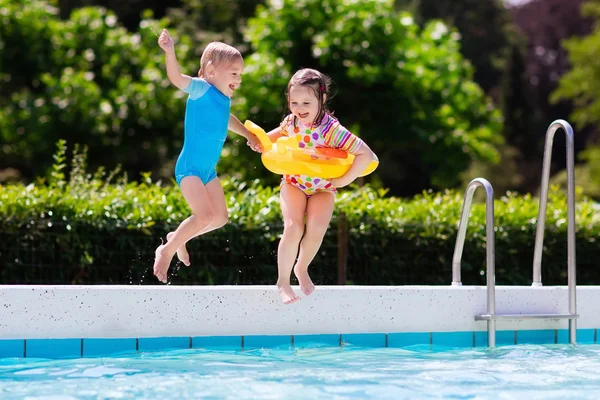 Crianças pulando na piscina — Fotografia de Stock