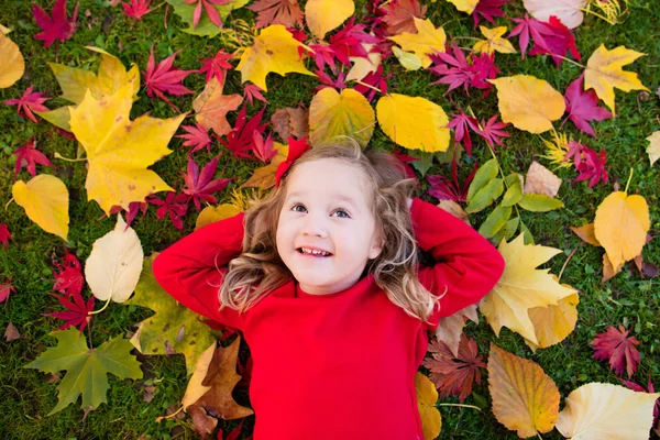 Little girl playing in autumn park — Stock Photo, Image