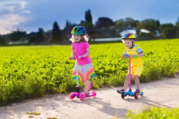 晴れた夏の日にスクーターに乗る子供たち — ストック写真