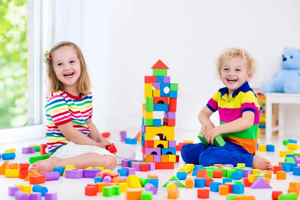 Crianças brincando com blocos de brinquedos coloridos — Fotografia de Stock