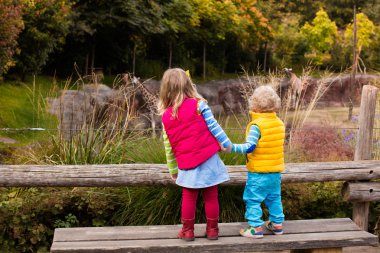 Hayvanat bahçesi hayvanları izlerken çocuklar