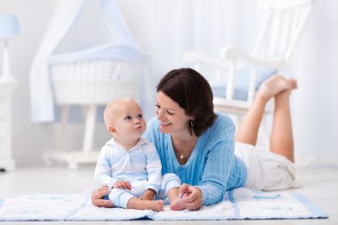 Mother and baby playing on the floor clipart