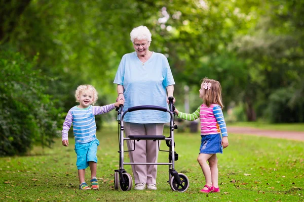 Mormor med walker leker med två barn — Stockfoto